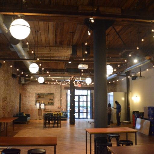 String lights G50 bulbs suspended in a V-Shaped pattern and wrapped around a column for a wedding at The Wythe Hotel located in Brooklyn New York