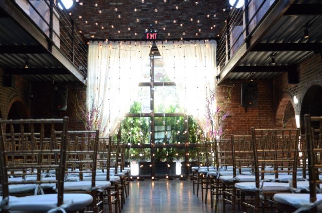 String Lights suspended overhead and vertically as a backdrop for a wedding ceremony in the main room at The Foundry located in Long Island City, New York
