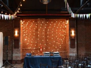 String Lights with multiple swoops against wall with pennant flags suspended at 26 Bridge located in Brooklyn, New York