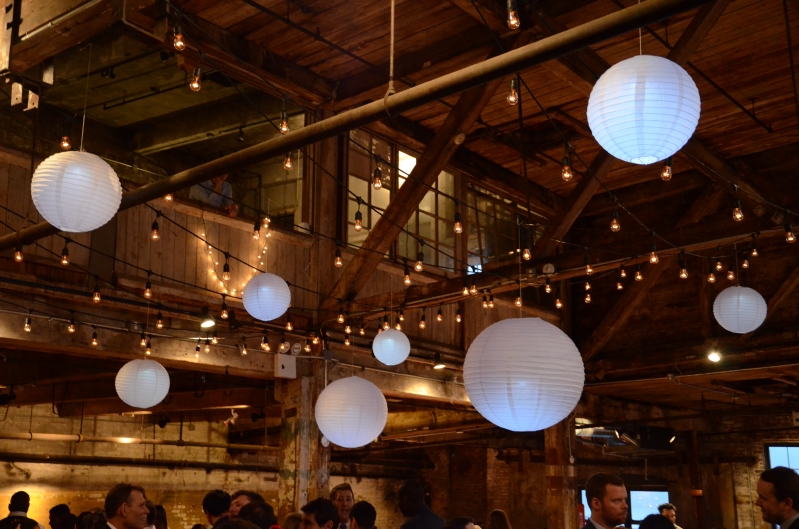 The Greenpoint Loft (Brooklyn, NY) - 300ft of String Lights with S14 bulbs suspended in  a zigzag pattern with Paper Lanterns under half  of the high ceiling area on the main floor.