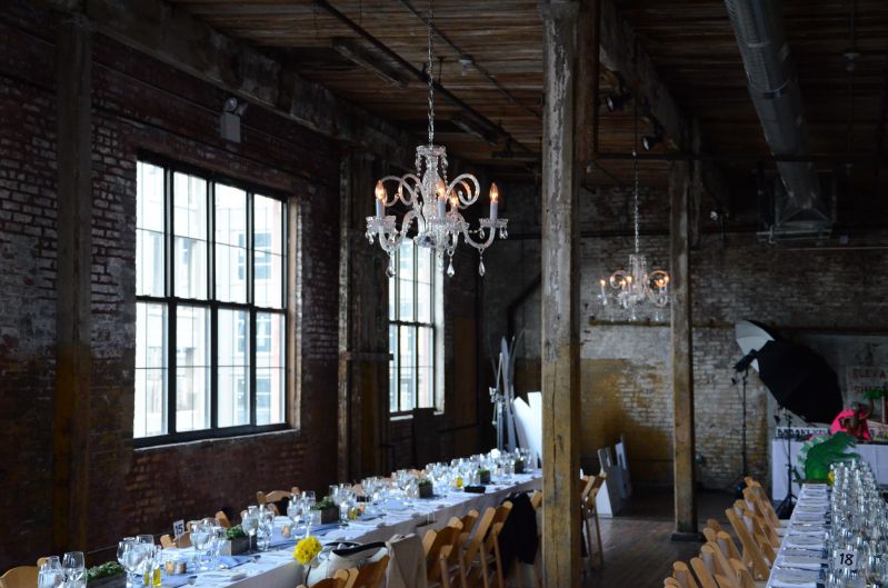 The Greenpoint Loft (Brooklyn, NY) - Chandeliers suspended to the side of the high ceiling area on the main floor.