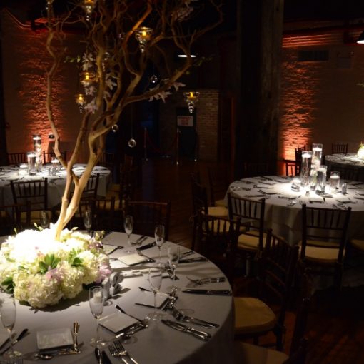 Pinspots focused on table centerpieces and Up-lights along the perimeter walls of the 1st floor at The Liberty Warehouse located in Brooklyn, NY