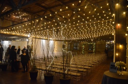 A canopy of String Light suspended between center columns at The Greenpoint Loft along with String Lights wrapped around center columns.