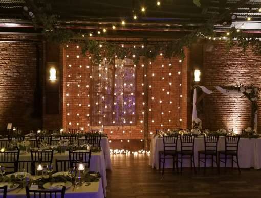 String Lights hanging vertically as a backdrop behind the ceremony area for a wedding at 26 Bridge (Brooklyn, NY)