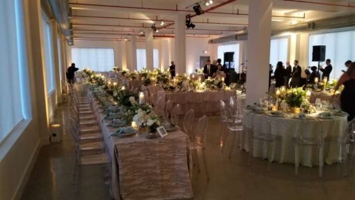 Pinspots focused on floral centerpieces with warm white Up-Lights along the perimeter walls at The Bordone