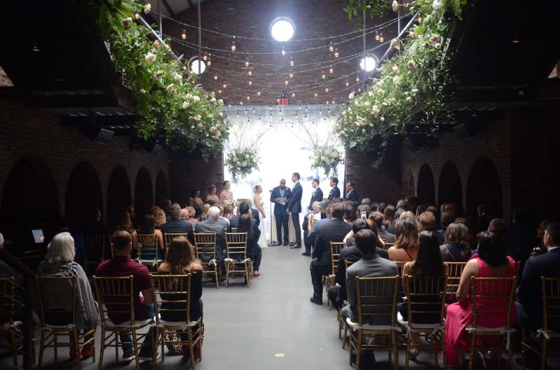 String Lights with warm white bulbs and florals hanging overhead in the Main Room at The Foundry.