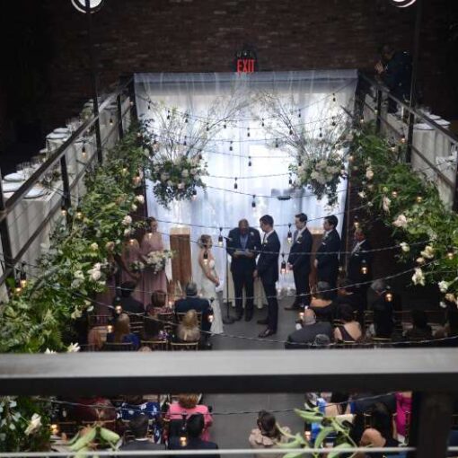 String Lights with warm white bulbs and florals hanging overhead in the Main Room at The Foundry.