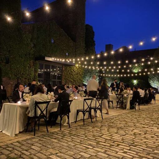 String Lights with Warm White bulbs suspended without lighting stands above the courtyard for a wedding at The Foundry.