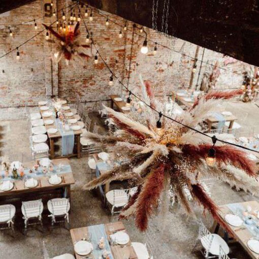 Warm White String Lights hanging in a circular pattern above the dance floor at The Houston Hall with a large floating floral installation at the center.