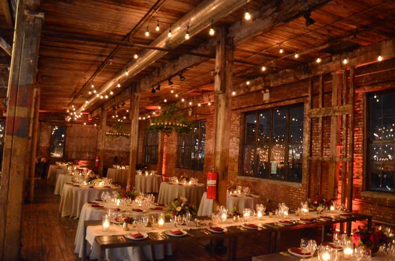 String Lights suspended in a parallel lines under lower ceiling area on the BAR and NON-BAR side of the main floor at The Greenpoint Loft with Circular Chandeliers and Votive Candles.