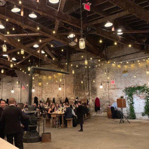 String Lights hanging above the main room for a wedding reception at The Houston Hall located in New York City