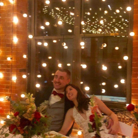 String Lights hanging vertically behind ceremony at The Dumob Loft