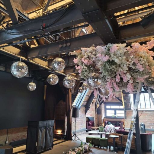A cluster of mirror balls at a wedding reception hosted at The Forografisca Museum in NYC. Florals provided and suspended by Ivie Joy Floral Arts.