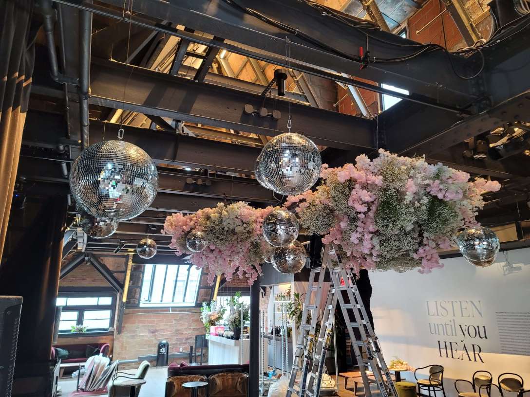 A cluster of mirror balls at a wedding reception hosted at The Forografisca Museum in NYC. Florals provided and suspended by Ivie Joy Floral Arts.