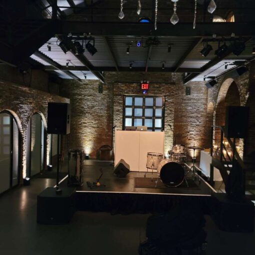 12ft x 12ft stage in the main room at the foundry with Up-Lights along the perimeter walls