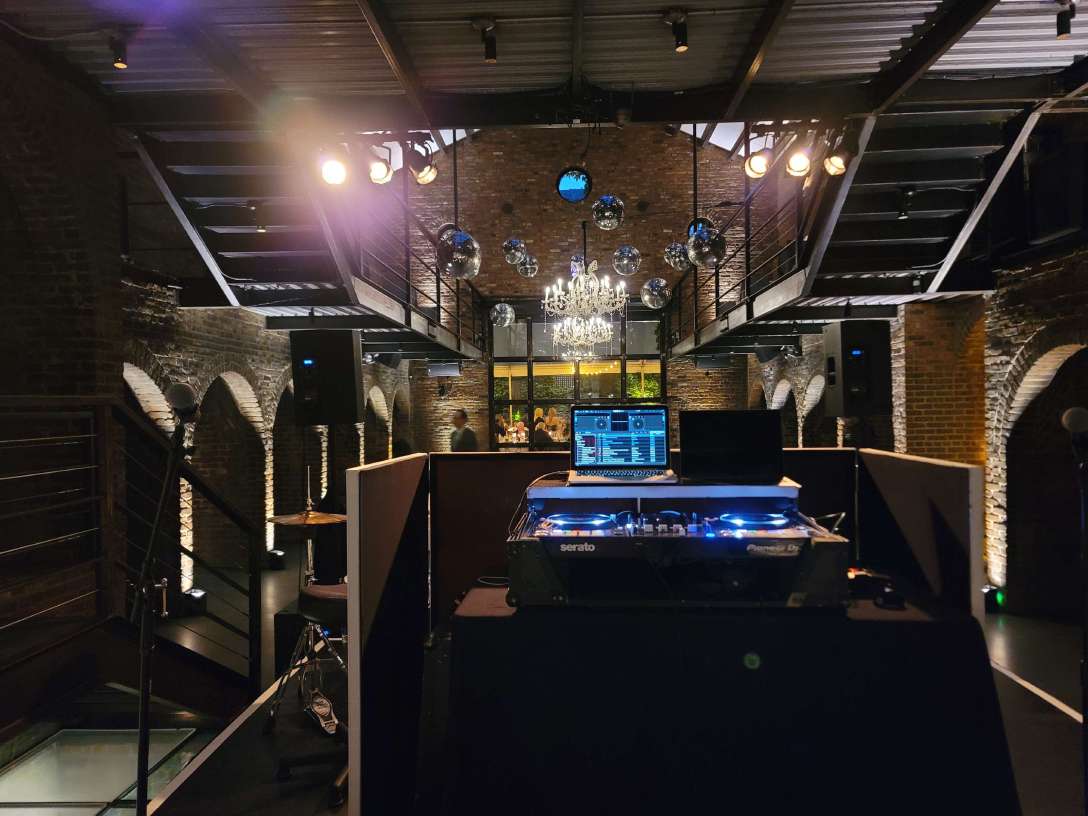 12ft x 12ft stage in the main room at the foundry with a crystal chandelier., mirror balls and Up-Lights along the perimeter walls