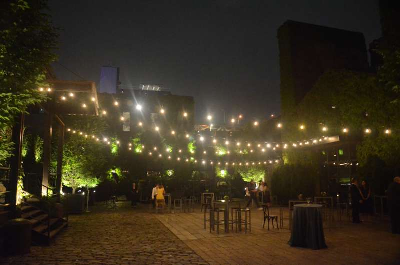 Bistro Lighting with Warm White bulbs suspended without lighting stands above the courtyard for a wedding at The Foundry.