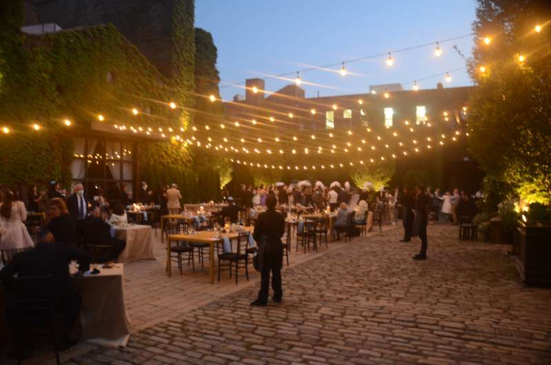 String Lighting with Warm White bulbs suspended without lighting stands above the courtyard for a wedding at The Foundry.