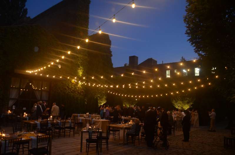 String Lighting with Warm White bulbs suspended without lighting stands above the courtyard for a wedding at The Foundry.