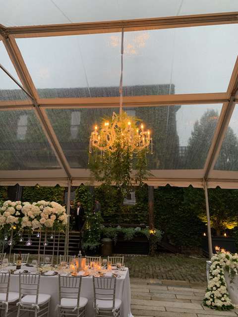 A 40" Crystal Chandelier suspended under a clear top tent in the courtyard for a wedding at The Foundry (Long Island City, NY).