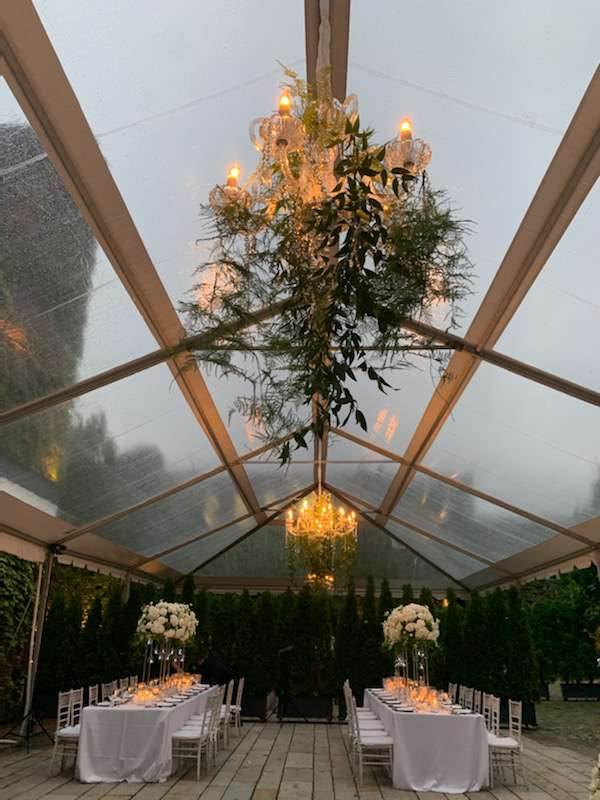 A 24" and 40" Crystal Chandelier suspended under a clear top tent in the courtyard for a wedding at The Foundry (Long Island City, NY).
