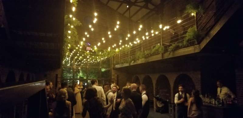 String lights with warm white bulbs and florals are hanging overhead in the main room at The Foundry.