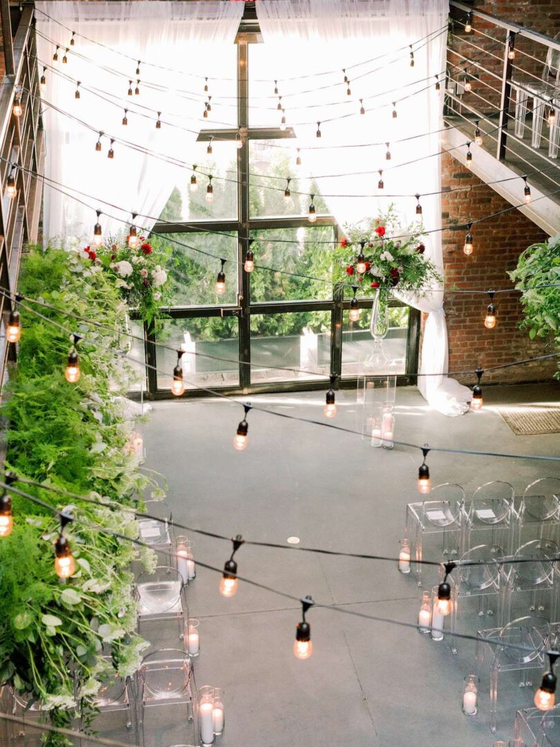 String lights with warm white bulbs and florals are hanging overhead in the main room at The Foundry.