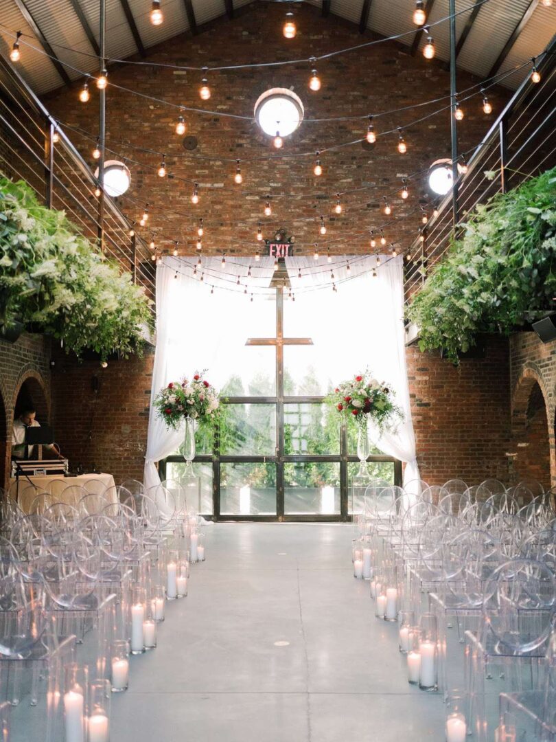 Decorative String lighting with warm white bulbs and florals are hanging overhead in the main room for a wedding at The Foundry.