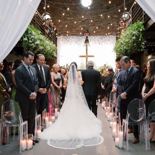 Decorative String lighting with warm white bulbs and florals are hanging overhead in the main room for a wedding at The Foundry.