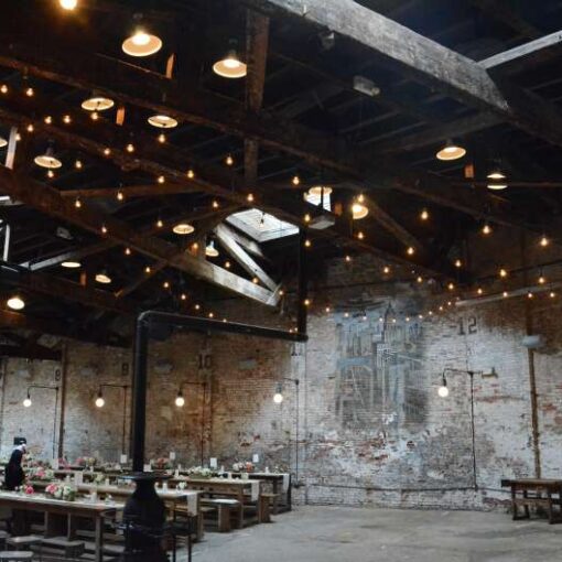 String Lights with warm white S14 bulbs hanging in a V-shaped pattern for a wedding at The Houston Hall