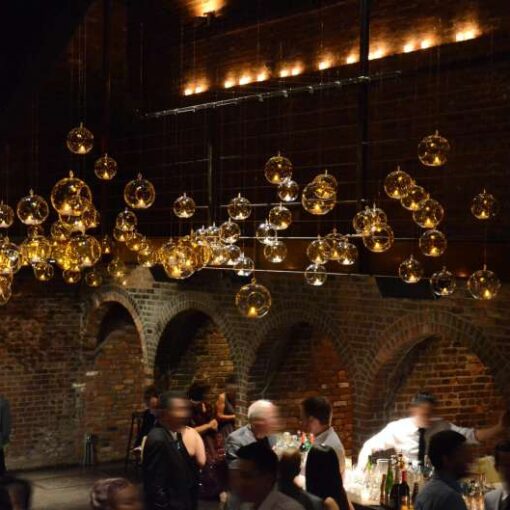Round glass balls hanging across the mezzanine level for a wedding in The Main Room at The Foundry.