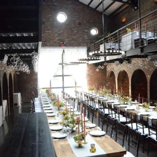 Circular Chandeliers with Votive Candles hanging across the mezzanine level with round glass balls handing under the mezzanine level for a wedding in The Main Room at The Foundry.
