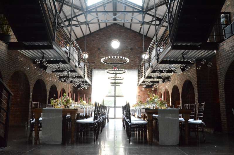 Circular Chandeliers with Votive Candles hanging across the mezzanine level with round glass balls handing under the mezzanine level for a wedding in The Main Room at The Foundry.