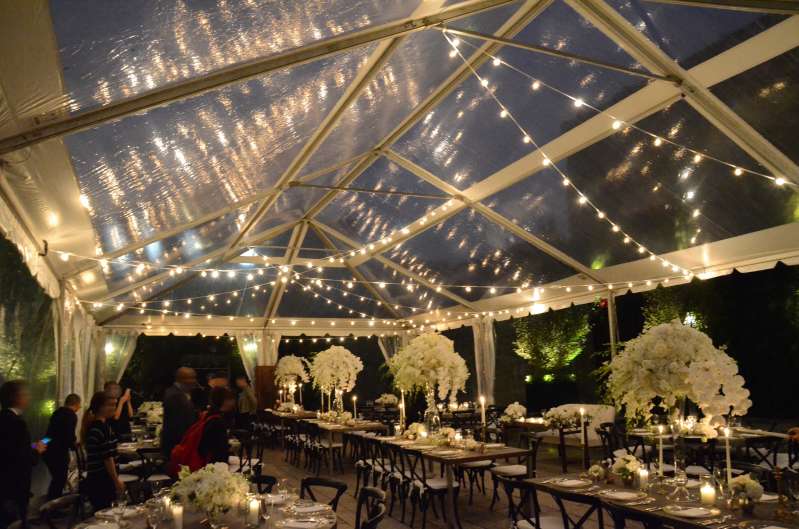 Warm White String Lights hanging in a random zigzagging pattern under a clear top tent for a wedding at The Foundry.