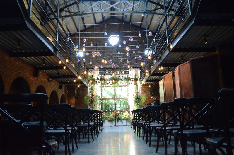 Pendant lamps with Edison bulbs are hanging in the main room across the mezzanine level for an industrial wedding at The Foundry.
