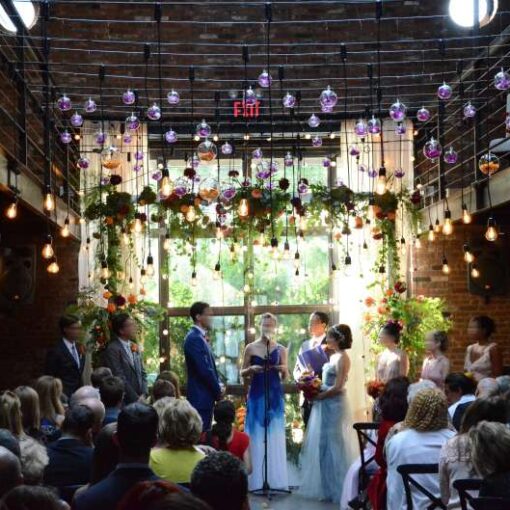 Pendant lamps with Edison bulbs are hanging in the main room across the mezzanine level for an industrial wedding at The Foundry.