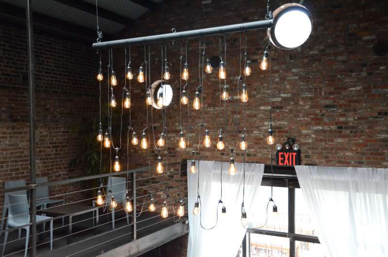 A custom chandelier created from string lights hanging in The Main Room for a wedding at The Foundry.