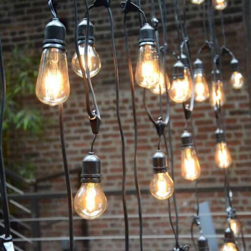 A custom chandelier created from string lights hanging in The Main Room for a wedding at The Foundry.