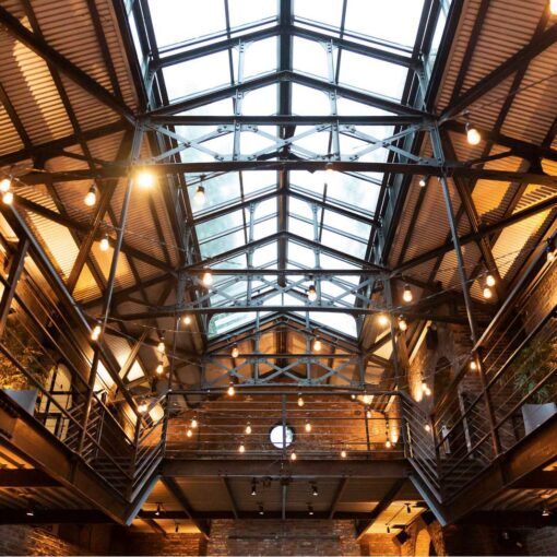 Warm White String Lights hanging in the main room for a wedding at The Foundry.