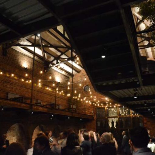 Warm White zigzagging string lights hanging in the main room for a fundraising event at The Foundry.