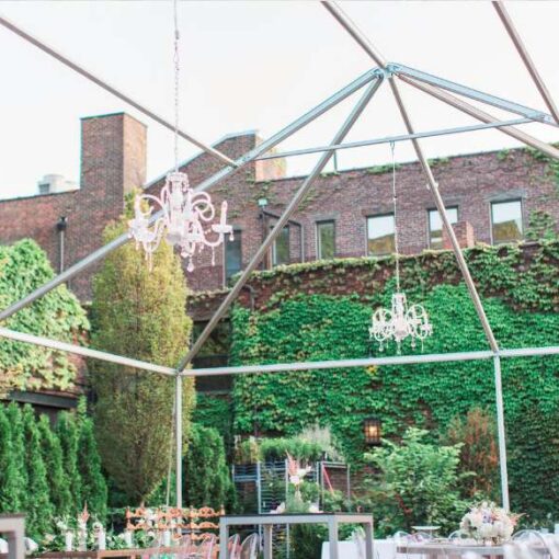 Crystal chandeliers hanging on a raw tent frame for an outdoor wedding in The Courtyard at The Foundry.