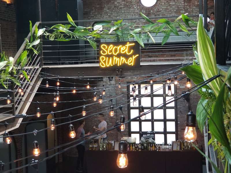 Decorative string lights hanging in the main room for The Secret Summer event hosted at The Foundry.