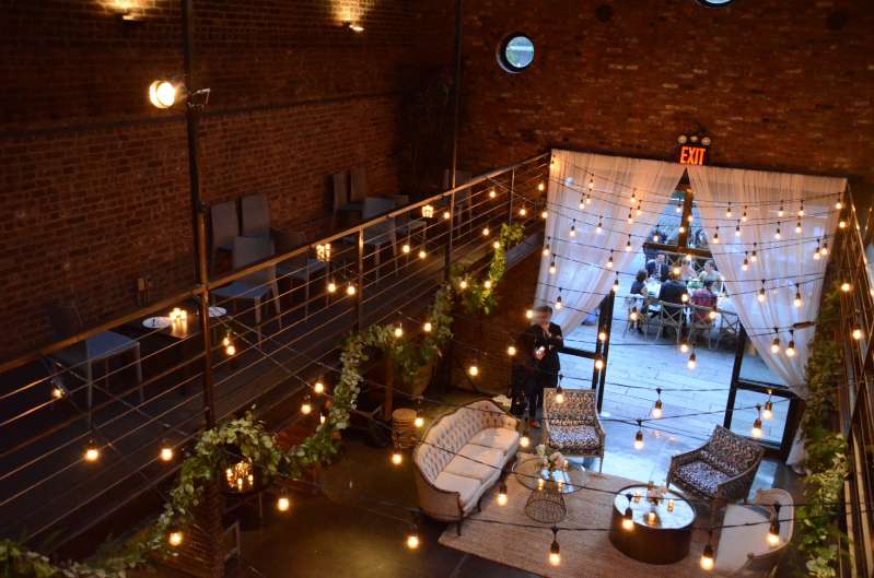 Zigzagging Warm White String Lights hanging in the main room across the mezzanine level for a wedding at The Foundry.