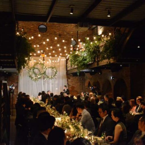 String lights with florals hang from the railing of the mezzanine level for a wedding in the main room at The Foundry.