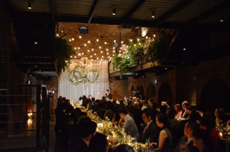 String lights with florals hang from the railing of the mezzanine level for a wedding in the main room at The Foundry.