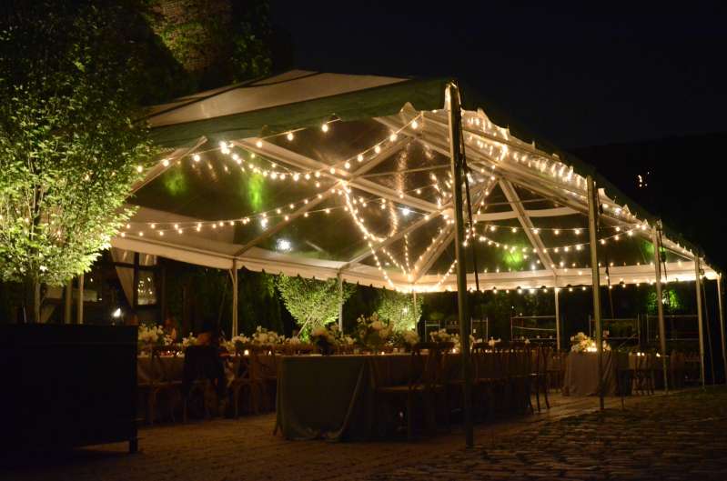 Warm White String Lights hanging in a random zigzagging pattern under a clear top tent for a wedding in the courtyard at The Foundry.