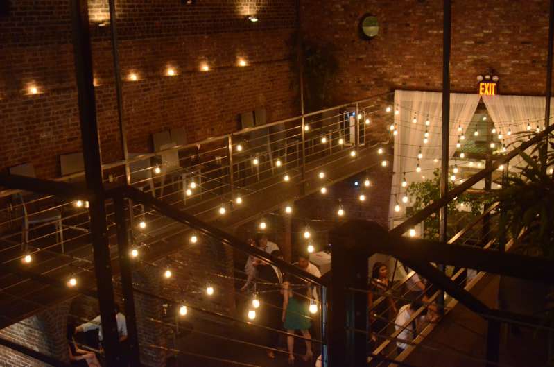 Warm White String Lights hanging in the main room across the mezzanine level for a wedding at The Foundry