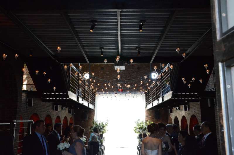Warm White String Lights hanging in a zigzag pattern from the mezzanine level for a wedding in the main room at The Foundry.