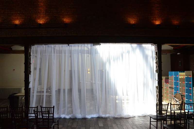 White Sheer Curtains hanging as a backdrop behind ceremony area for a wedding at 26 Bridge.