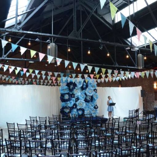 String Lights along with Bunting Flags hanging over the majority of the main room for a wedding at 26 Bridge. 